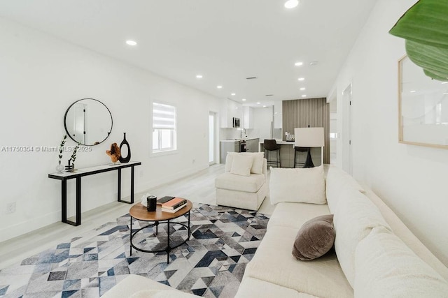 living room featuring light wood-style flooring, baseboards, and recessed lighting