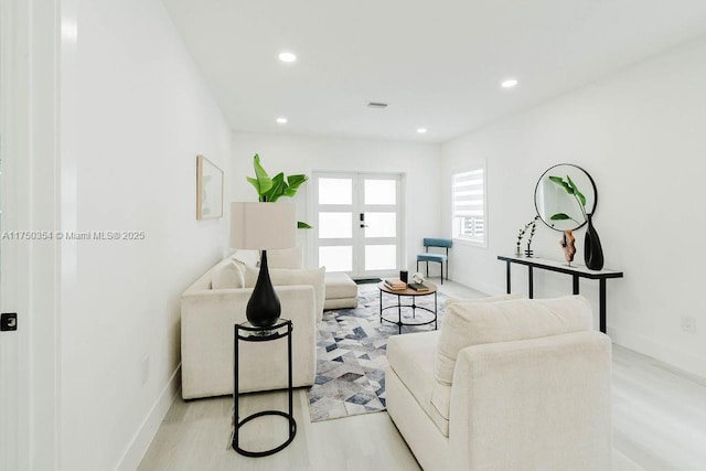 living area with baseboards, light wood-style floors, visible vents, and recessed lighting