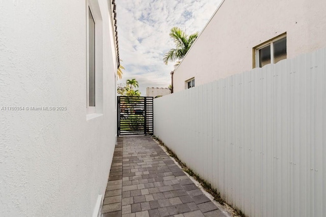 view of property exterior with a gate and stucco siding