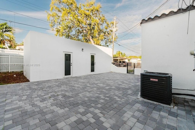 view of patio with cooling unit and fence