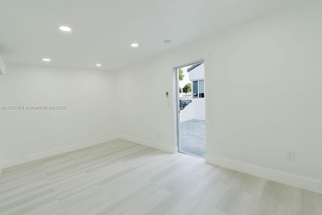 unfurnished room with baseboards, recessed lighting, and light wood-style floors