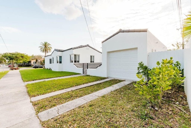 view of side of home with a lawn, fence, and stucco siding