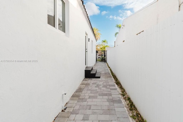 view of side of property with fence and stucco siding