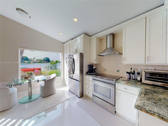 kitchen featuring wall chimney exhaust hood, tasteful backsplash, white cabinets, and stainless steel appliances