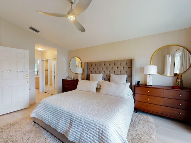 bedroom with lofted ceiling, connected bathroom, visible vents, and a ceiling fan