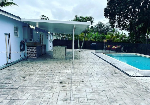 view of pool with a grill, fence, a fenced in pool, and a patio