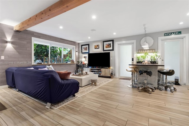 living room featuring baseboards, wood finish floors, beamed ceiling, and recessed lighting