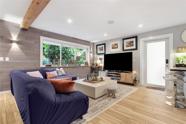 living room featuring light wood finished floors, beamed ceiling, and recessed lighting