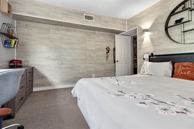 bedroom with carpet floors, wooden walls, and visible vents