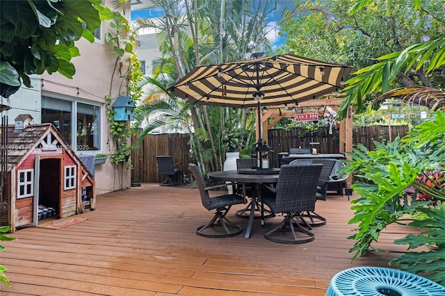 wooden deck with outdoor dining space and fence