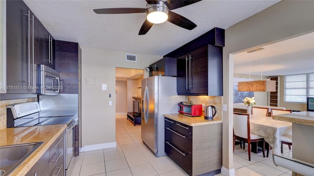 kitchen featuring tasteful backsplash, light countertops, visible vents, appliances with stainless steel finishes, and a sink