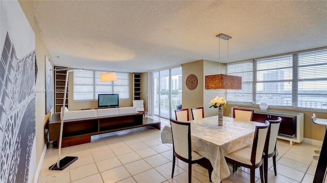 dining room with a textured ceiling, light tile patterned floors, and baseboards