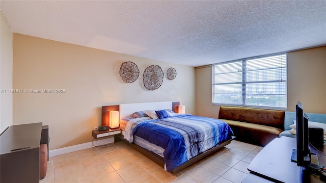 bedroom with light tile patterned floors, baseboards, and a textured ceiling