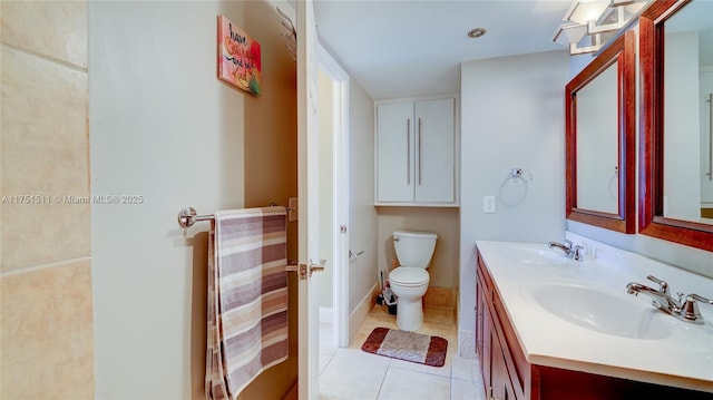 full bath featuring double vanity, tile patterned flooring, a sink, and toilet