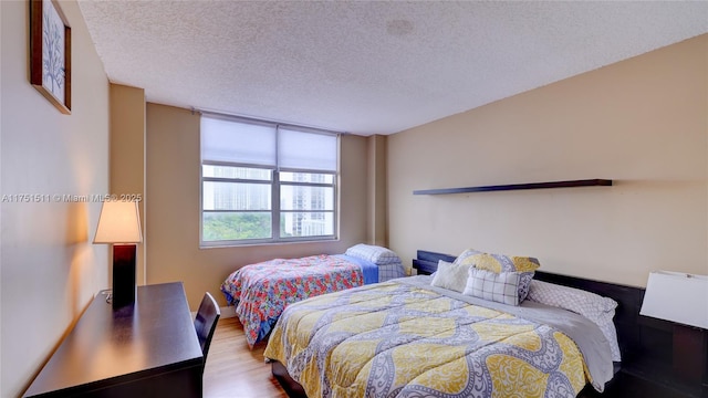 bedroom with light wood-type flooring and a textured ceiling