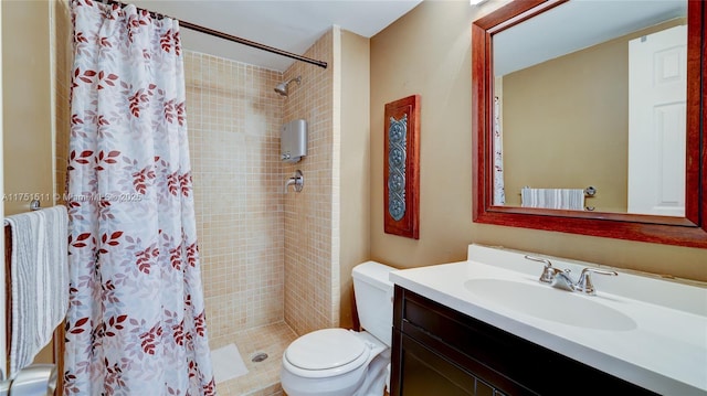 bathroom with toilet, a shower stall, and vanity