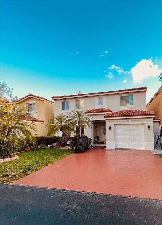 view of front facade with a garage, driveway, a tile roof, and stucco siding