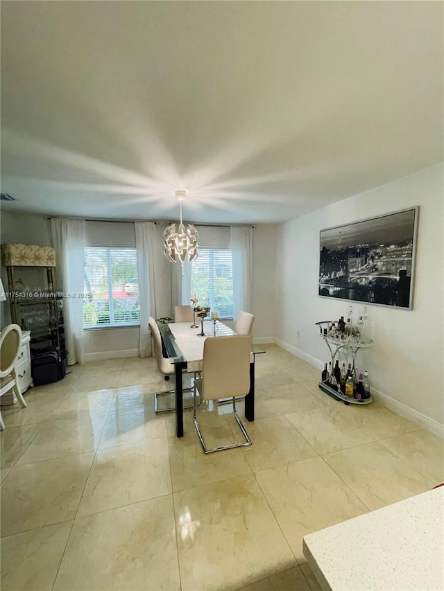 dining area with baseboards and a notable chandelier