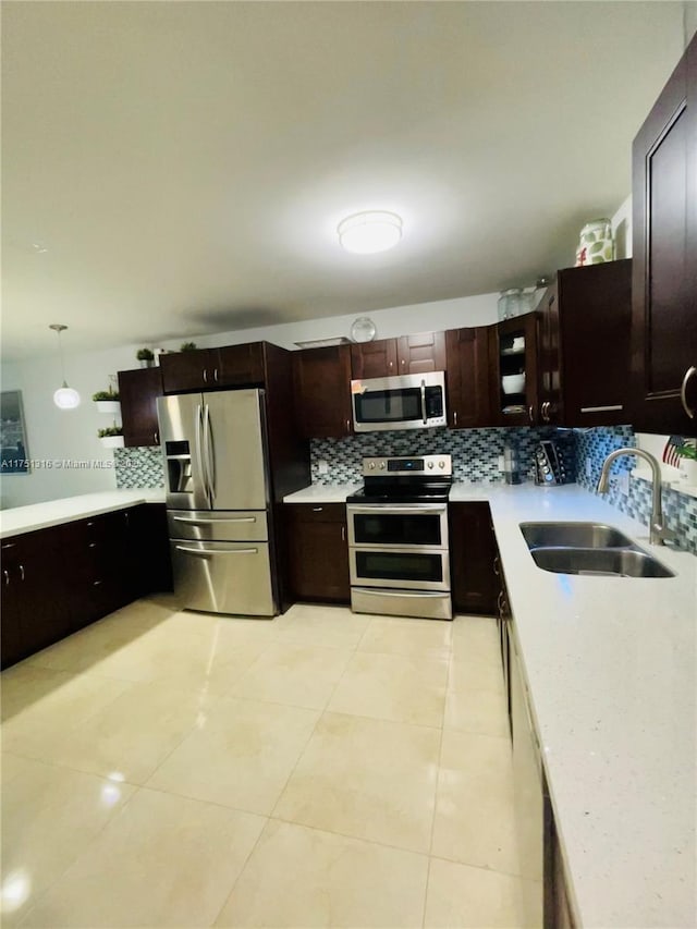 kitchen with stainless steel appliances, light countertops, and a sink