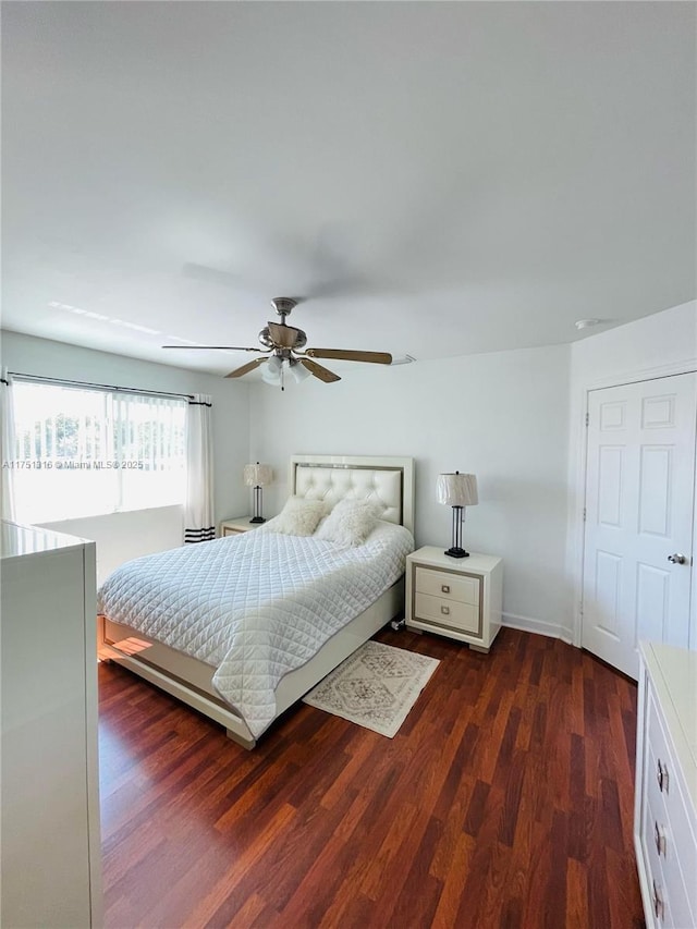 bedroom with dark wood-style floors, ceiling fan, and baseboards