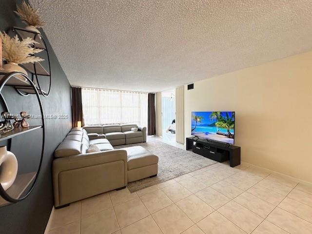 living room with light tile patterned floors, expansive windows, and a textured ceiling