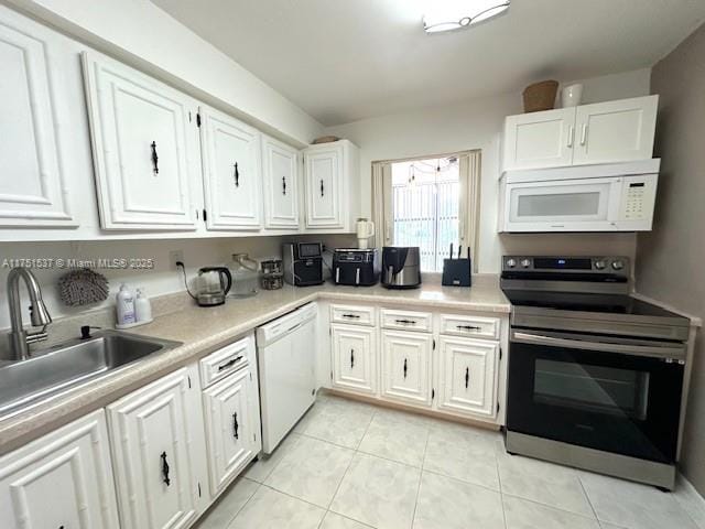 kitchen featuring light tile patterned floors, white appliances, a sink, white cabinetry, and light countertops