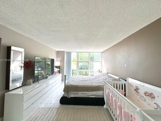 bedroom with a textured ceiling and light tile patterned floors