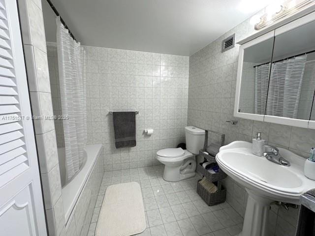 full bathroom with toilet, visible vents, tile walls, tile patterned floors, and shower / bathtub combination with curtain