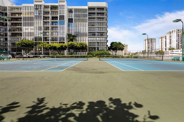 view of sport court with a view of city and fence