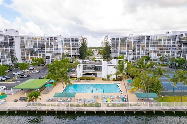 pool featuring a patio area and a water view