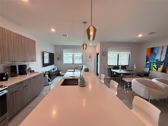 4640 NW 84th Ave Unit 13, Doral, FL 33166 - kitchen featuring open floor plan, a sink, light countertops, modern cabinets, and recessed lighting