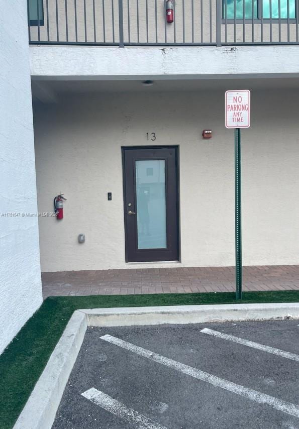 4640 NW 84th Ave Unit 13, Doral, FL 33166 - view of exterior entry with stucco siding and uncovered parking