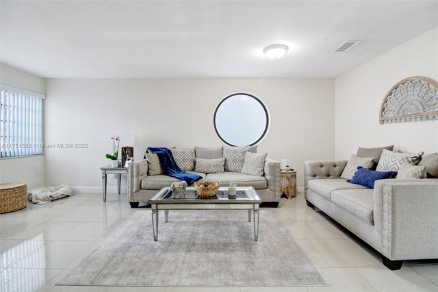 living area featuring visible vents, baseboards, and light tile patterned floors