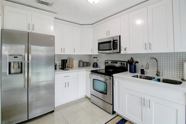 kitchen featuring light countertops, visible vents, decorative backsplash, appliances with stainless steel finishes, and a sink