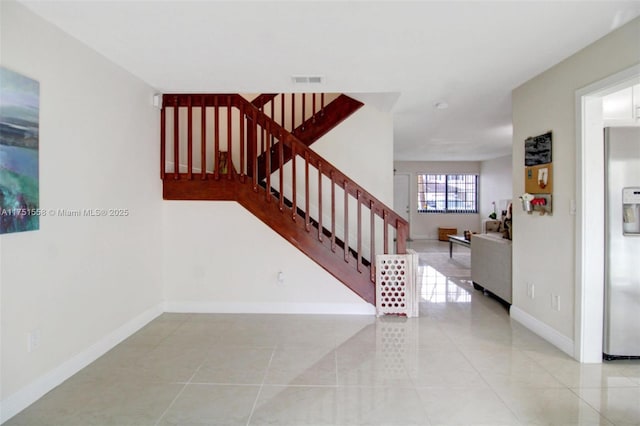 stairs featuring visible vents, baseboards, and tile patterned floors