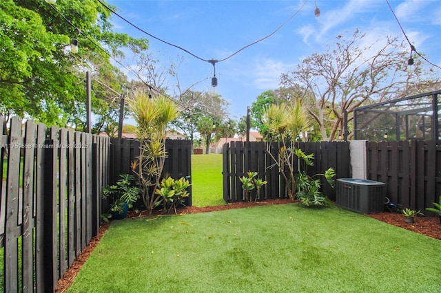 view of yard featuring a fenced backyard and central AC