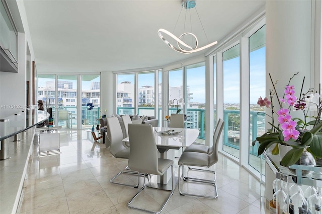 dining room with floor to ceiling windows, a chandelier, and a city view