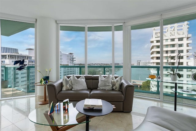 living room featuring expansive windows, marble finish floor, a water view, and a city view