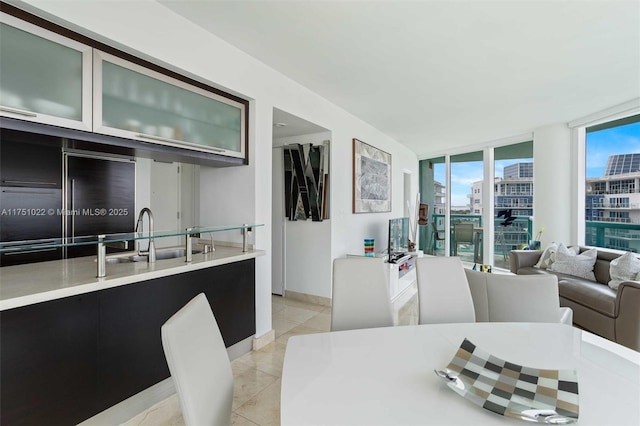 dining room with light tile patterned floors, expansive windows, and baseboards