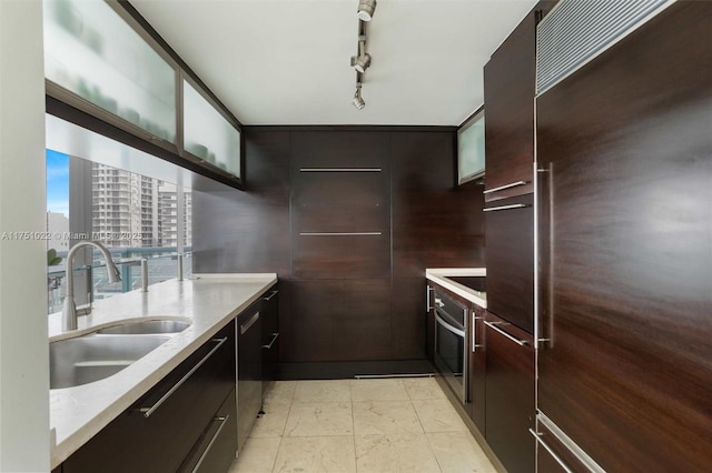 kitchen featuring a city view, stainless steel appliances, glass insert cabinets, a sink, and modern cabinets