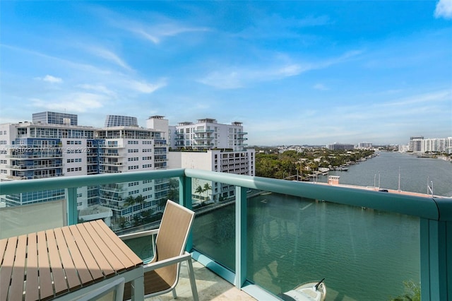 balcony featuring a water view and a city view