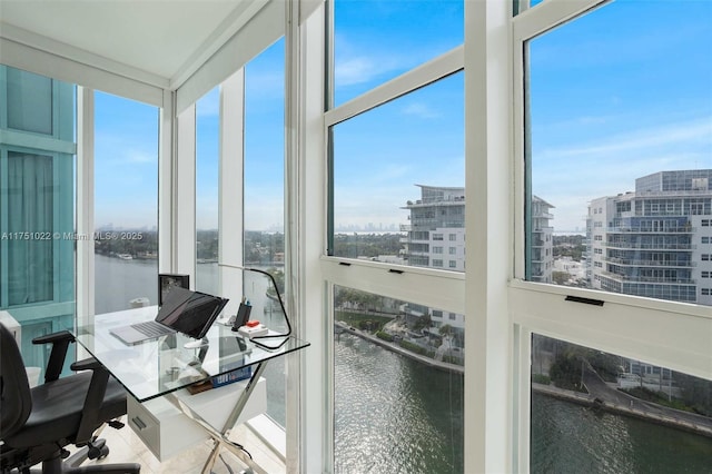 home office featuring a view of city, a healthy amount of sunlight, and a water view