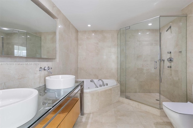 bathroom featuring double vanity, a sink, tile walls, and a shower stall