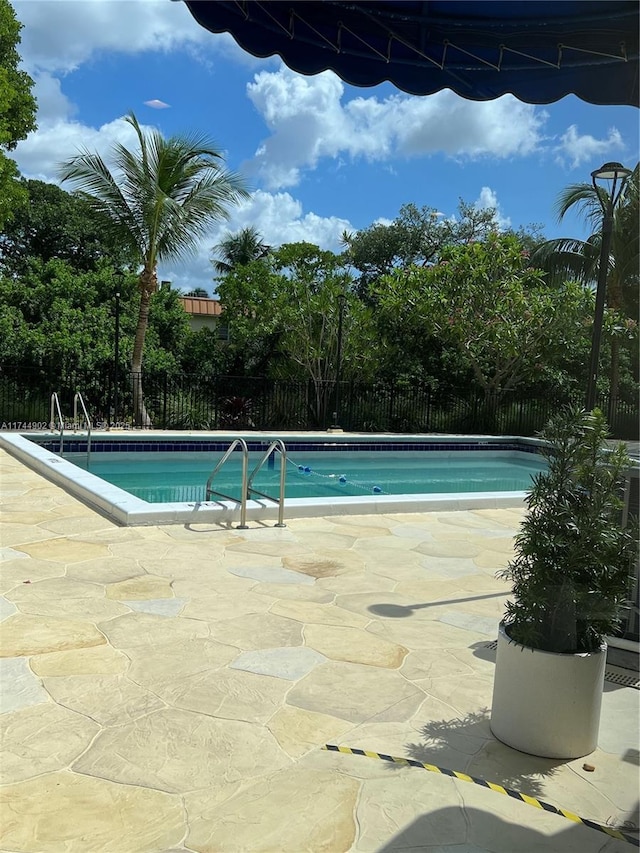 pool featuring a patio area and fence