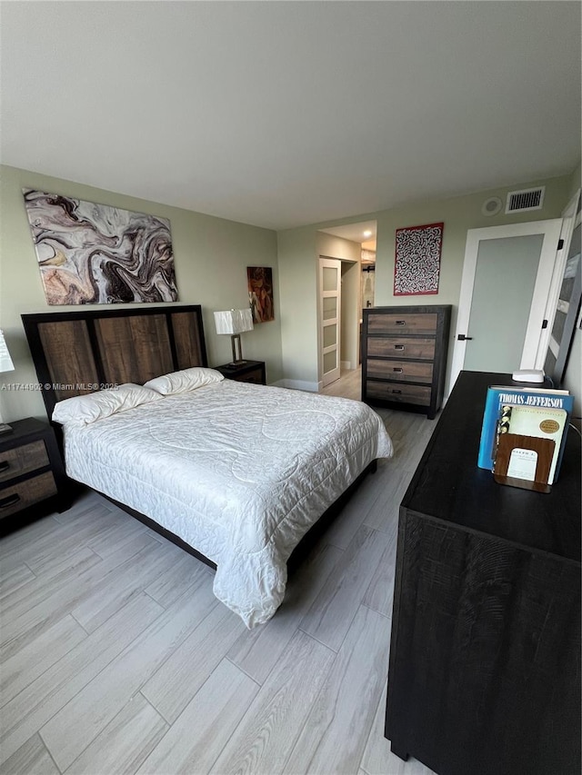 bedroom featuring visible vents and wood finished floors