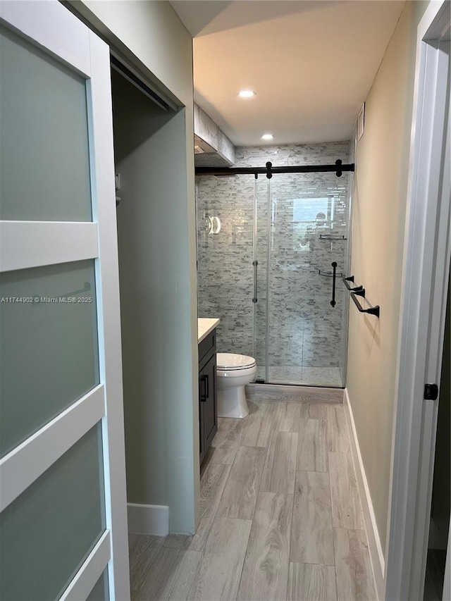 full bath with toilet, a shower stall, baseboards, and vanity