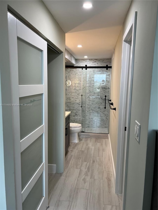 bathroom with a stall shower, vanity, toilet, and recessed lighting