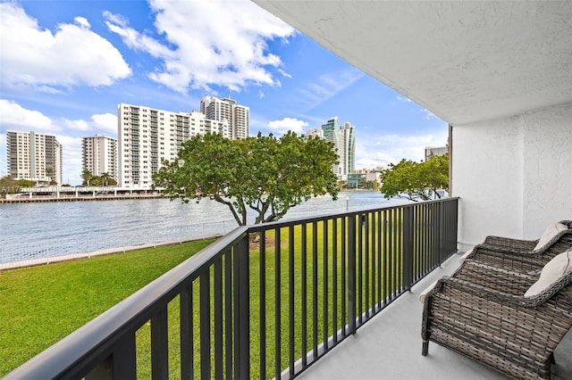 balcony featuring a water view and a city view