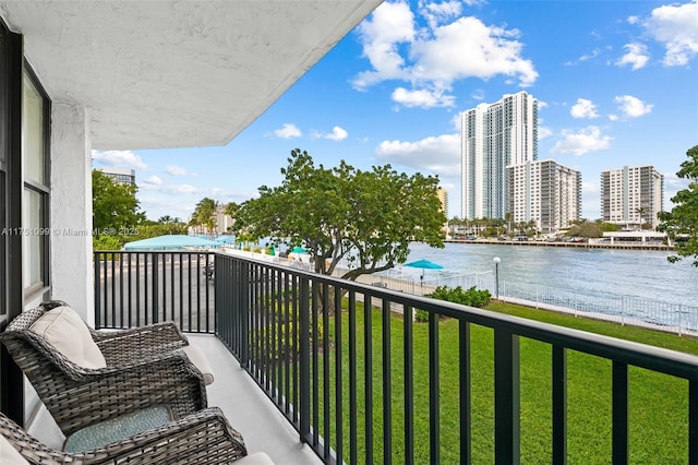 balcony featuring a water view and a city view