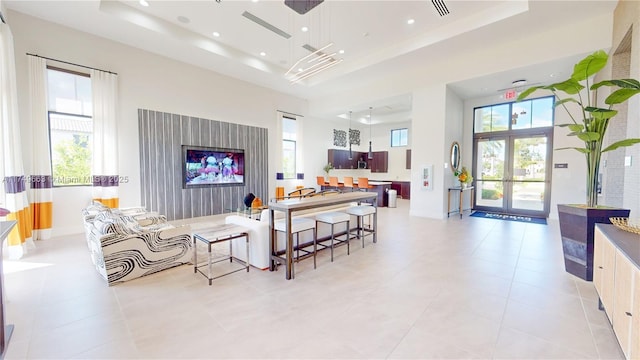 living room featuring a tray ceiling, recessed lighting, and a healthy amount of sunlight